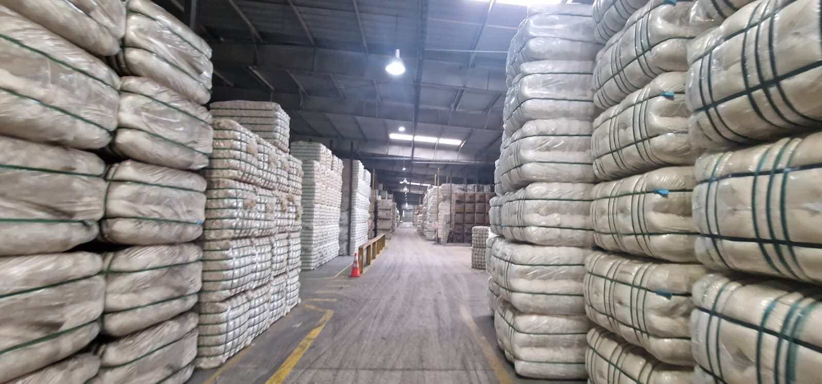 Warehouse in Uruguay with stacked, strapped wool bales ready for export.